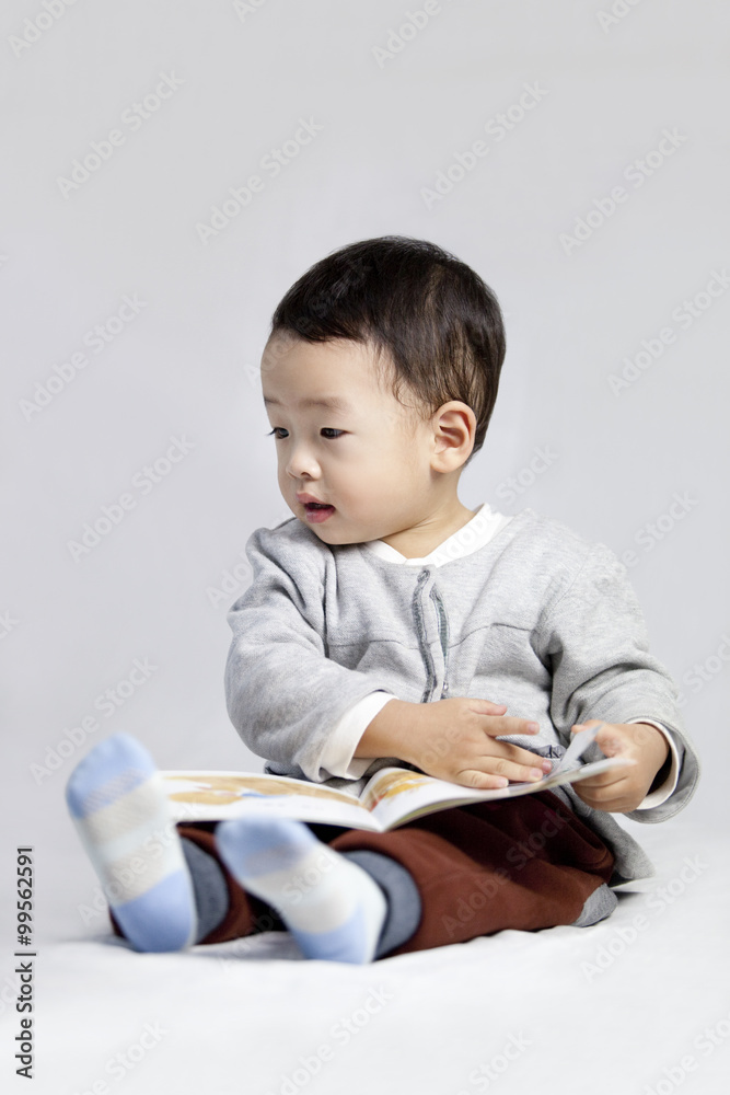 Cute little boy reading a book