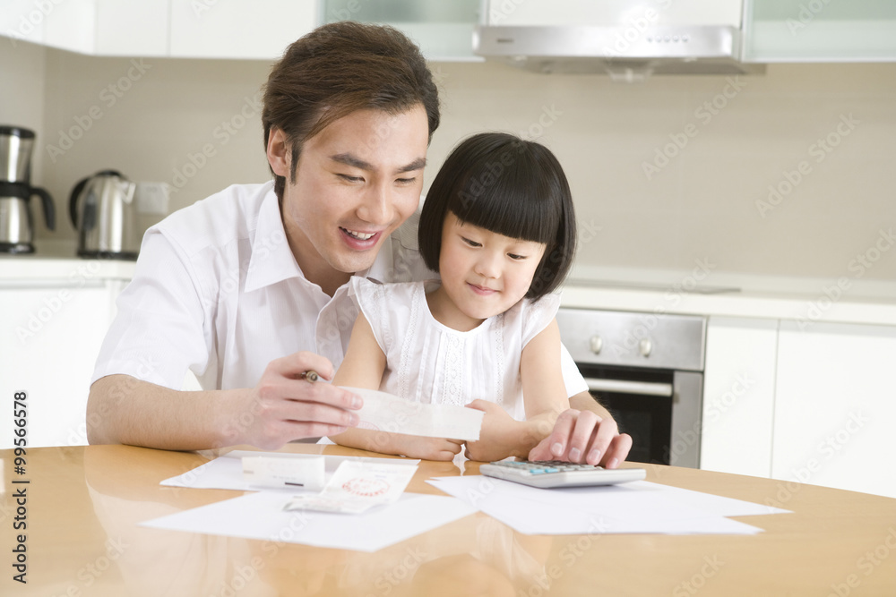 Father and daughter doing the household accounting Father and daughter doing the household accounting