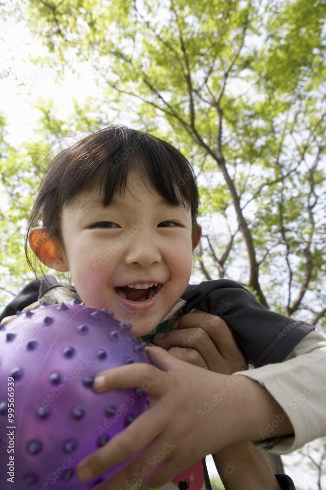 Young Girl Holding A Ball In The Park And Smiling Young Girl Holding A Ball In The Park And Smiling