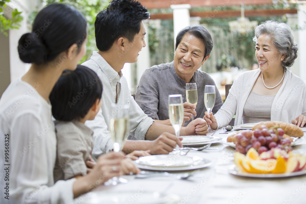 Happy multigenerational family eating outdoors Happy multigenerational family eating outdoors