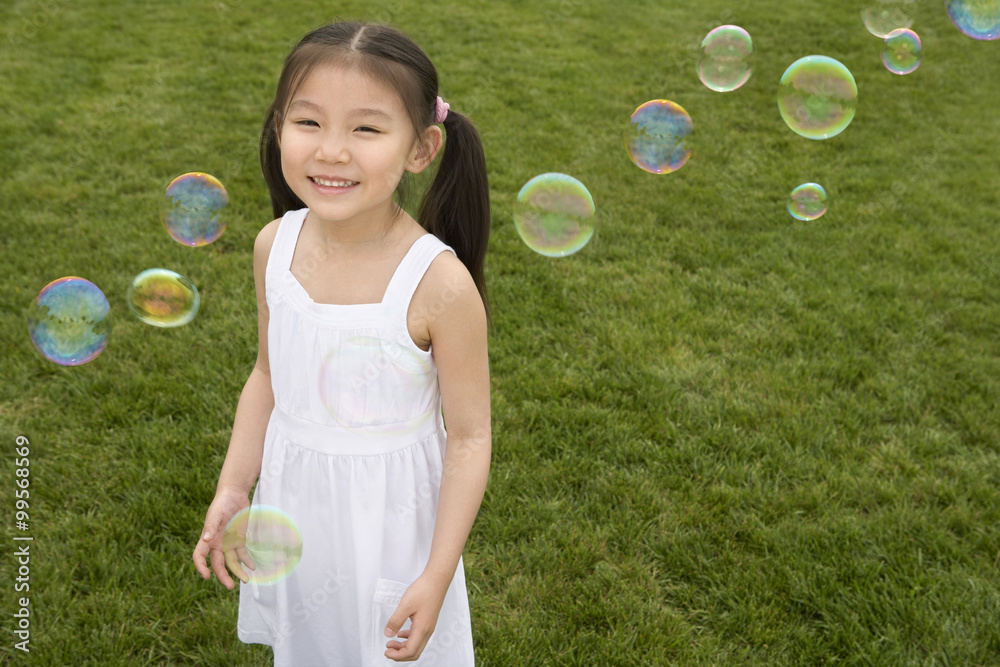 Young Girl Chasing Bubbles In Park Young Girl Chasing Bubbles In Park