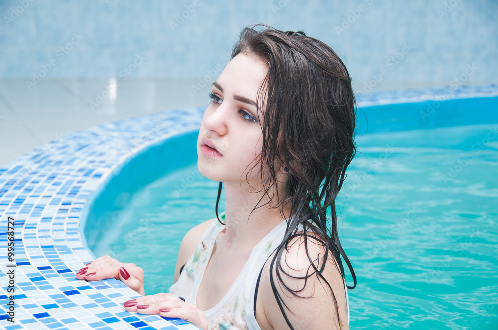 Portrait of young gorgeous woman posing in a swimming pool