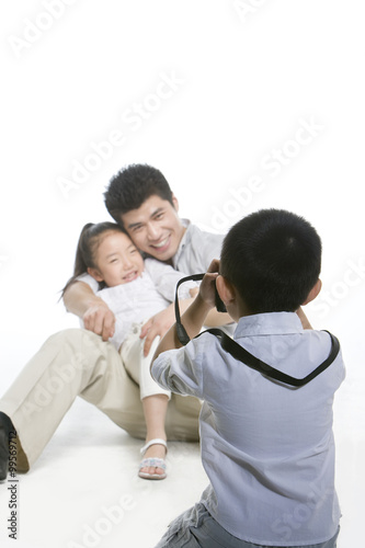 Boy taking photo for father and sister