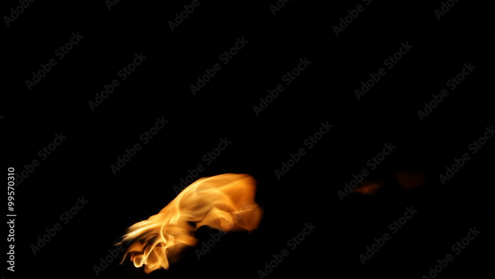 Tiki torch flame blowing in the wind at night on Kauai, Hawaii.