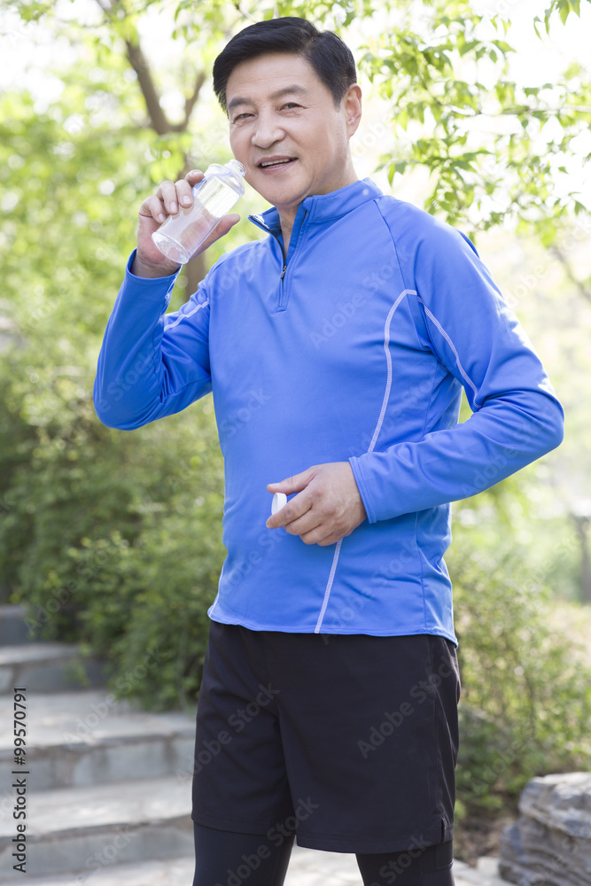 Happy mature man drinking water after exercising Happy mature man drinking water after exercising