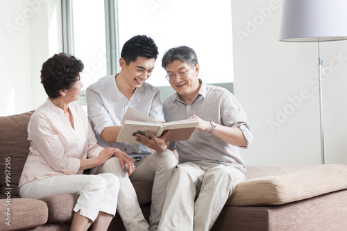 Happy family looking at photo album © Blue Jean Images