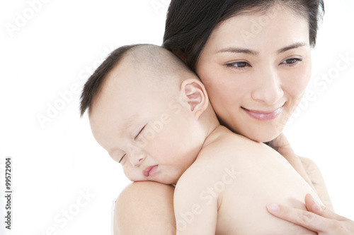 Close up of mother embracing sleeping baby