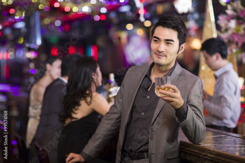 Young man drinking alcohol in bar
