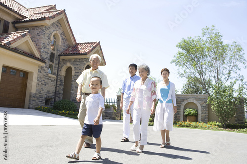 Three generation family walking by a house