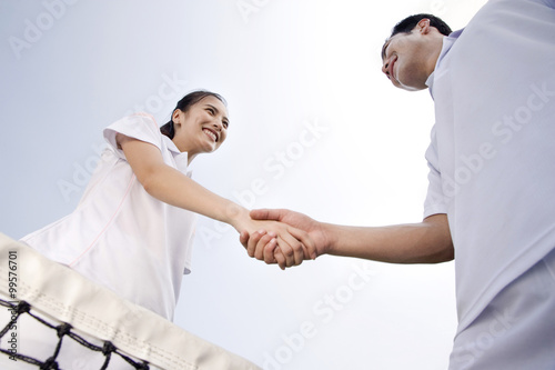Young couple shake hands on the tennis court