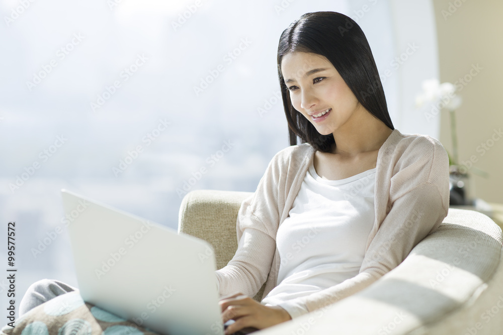 Young woman using laptop on couch