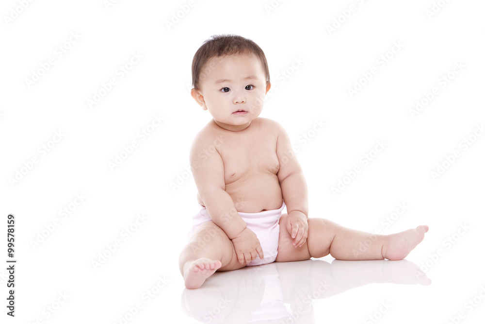 Studio shot of cute baby sitting on floor Studio shot of cute baby sitting on floor