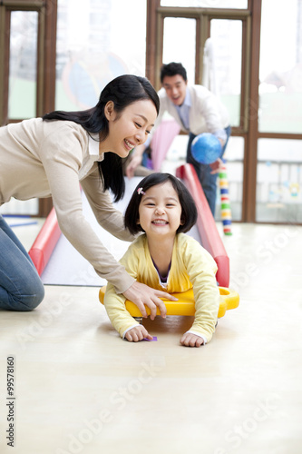 Little girl going down a slide in kindergarten