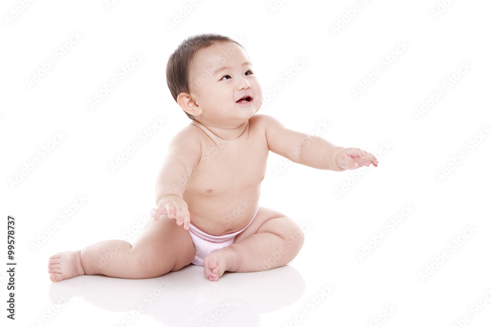 Studio shot of cute baby sitting on floor Studio shot of cute baby sitting on floor