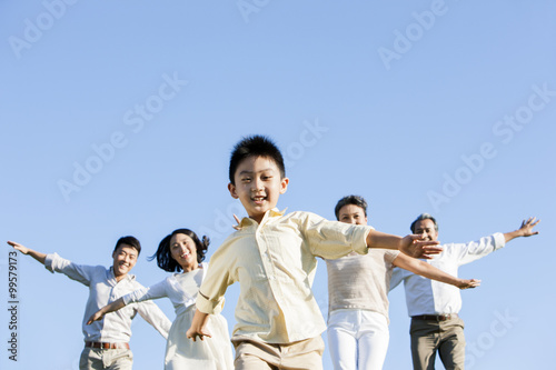 Happy family pretending to be flying in a park © Blue Jean Images