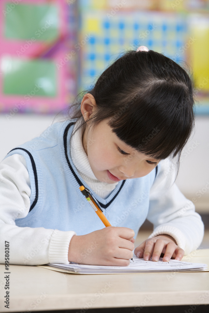 Young student writing in classroom Young student writing in classroom