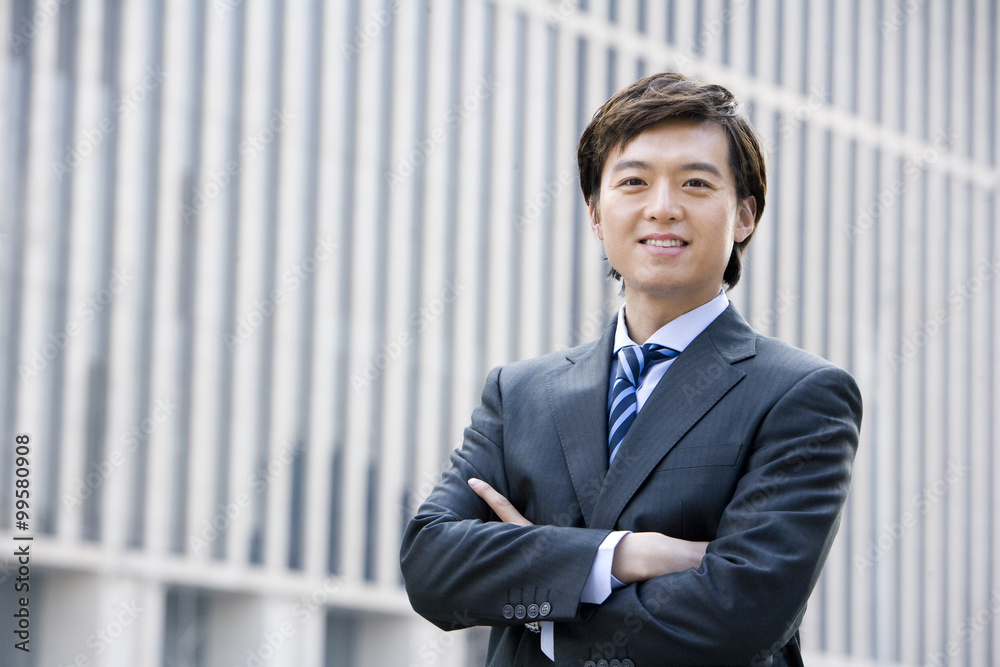 Confident businessman standing in front of downtown building Confident businessman standing in front of downtown building