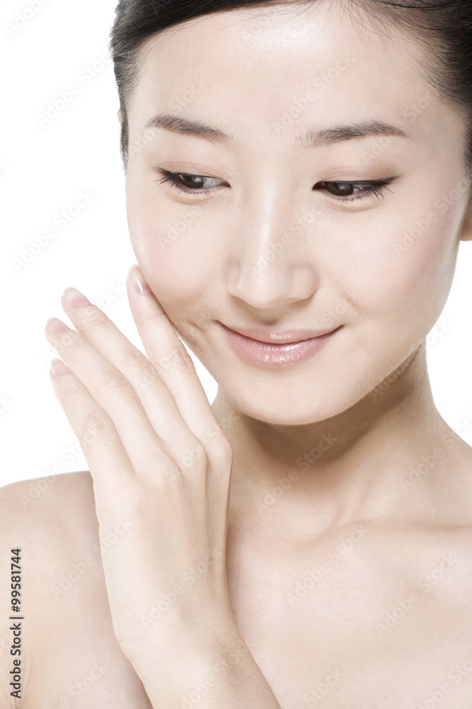 Beauty shot of a young woman touching her face Beauty shot of a young woman touching her face
