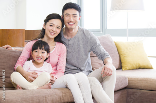 Happy young family sitting on sofa