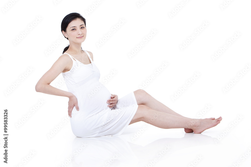 Cheerful pregnant woman sitting on floor Cheerful pregnant woman sitting on floor