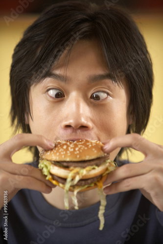 Teenage Boy Eating Hamburger
