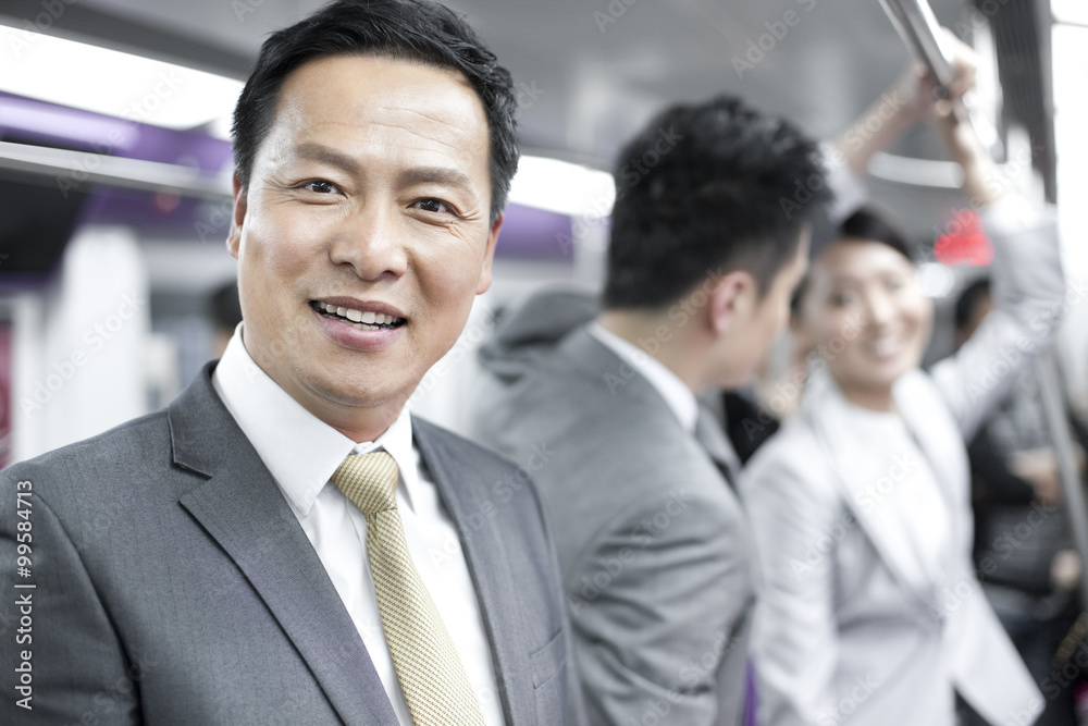 Cheerful businessman with partners in subway train Cheerful businessman with partners in subway train