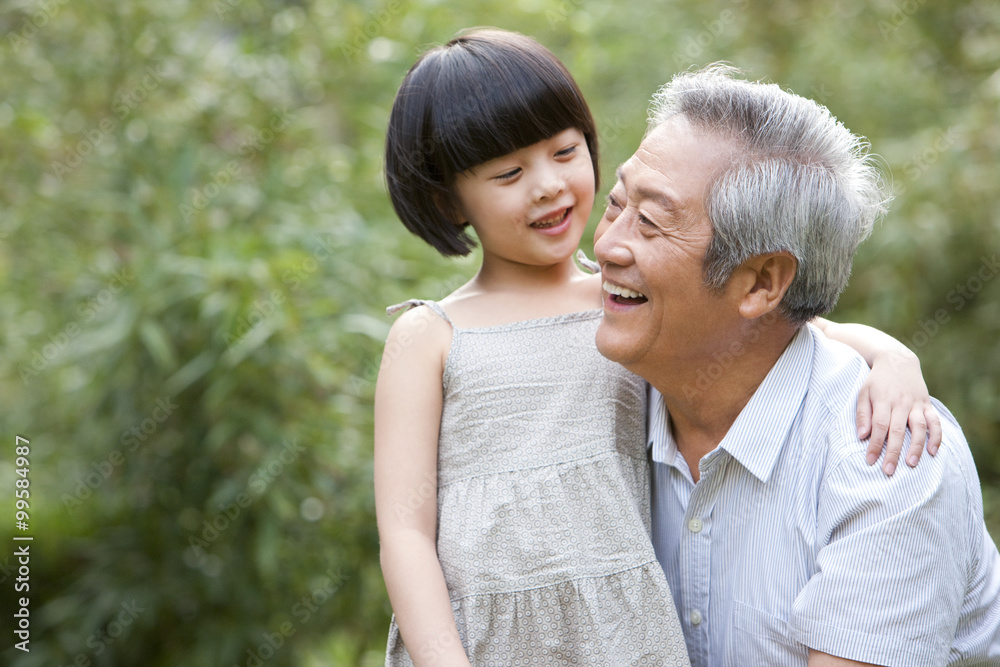 Grandfather and granddaughter having fun in garden Grandfather and granddaughter having fun in garden