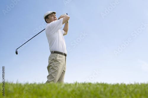 Male golfer swinging club