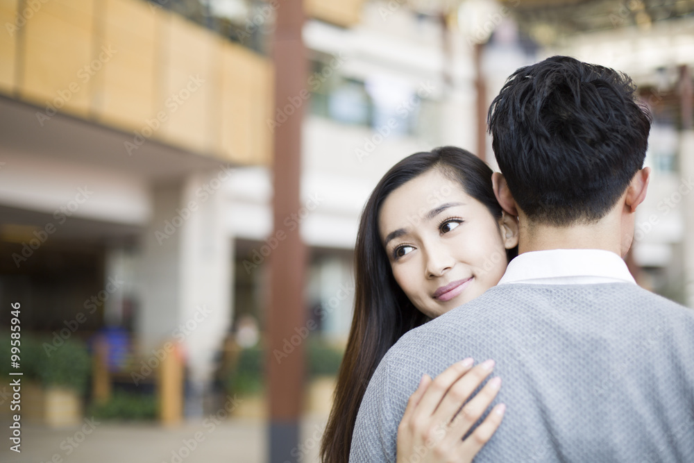 Young couple embracing in shopping mall Young couple embracing in shopping mall