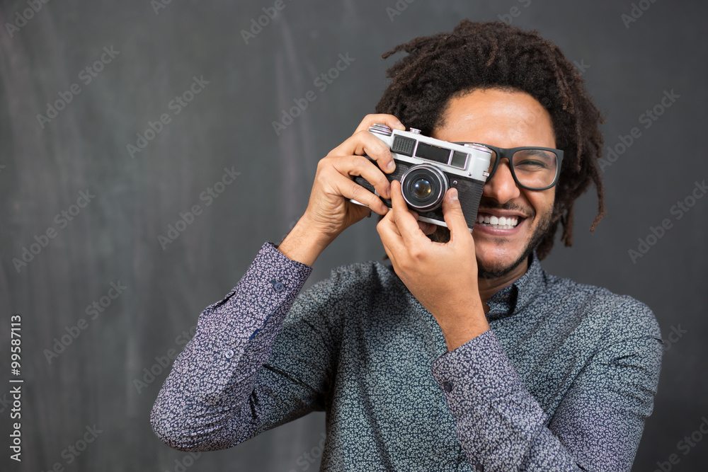 Portrait of a smiling afro american man making photo on retro ca Portrait of a smiling afro american man making photo on retro ca