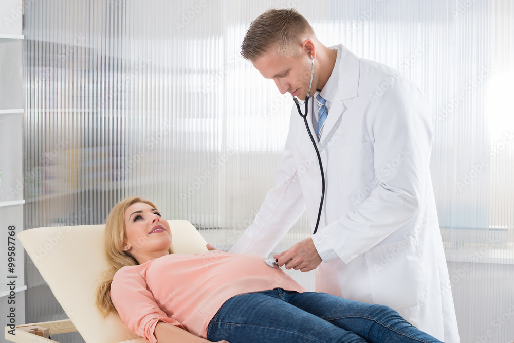 Fototapeta premium Doctor Examining Pregnant Woman With Stethoscope