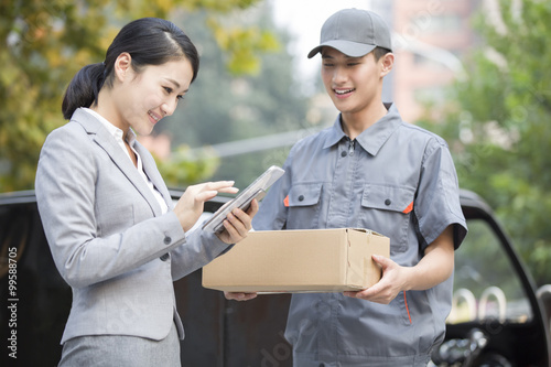 Young woman signing for the package