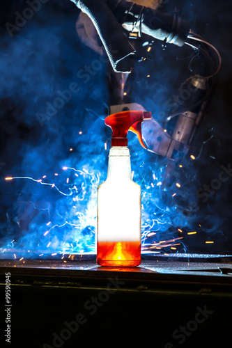 Plastic bottle with cleaning liquid glowing in front CNC Mig wel