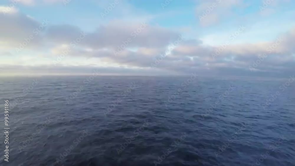 Beautiful scene: blue sunny sky with сumulus clouds, steam over the sea, the view from the boat Beautiful scene: blue sunny sky with сumulus clouds, steam over the sea, the view from the boat