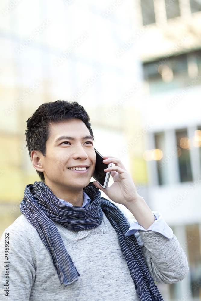 Fashionable young man talking on the phone in city Fashionable young man talking on the phone in city