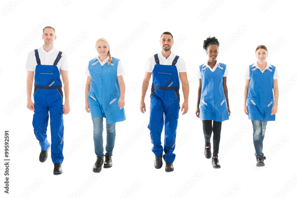 Portrait Of Confident Multiethnic Janitors Walking In Row Portrait Of Confident Multiethnic Janitors Walking In Row