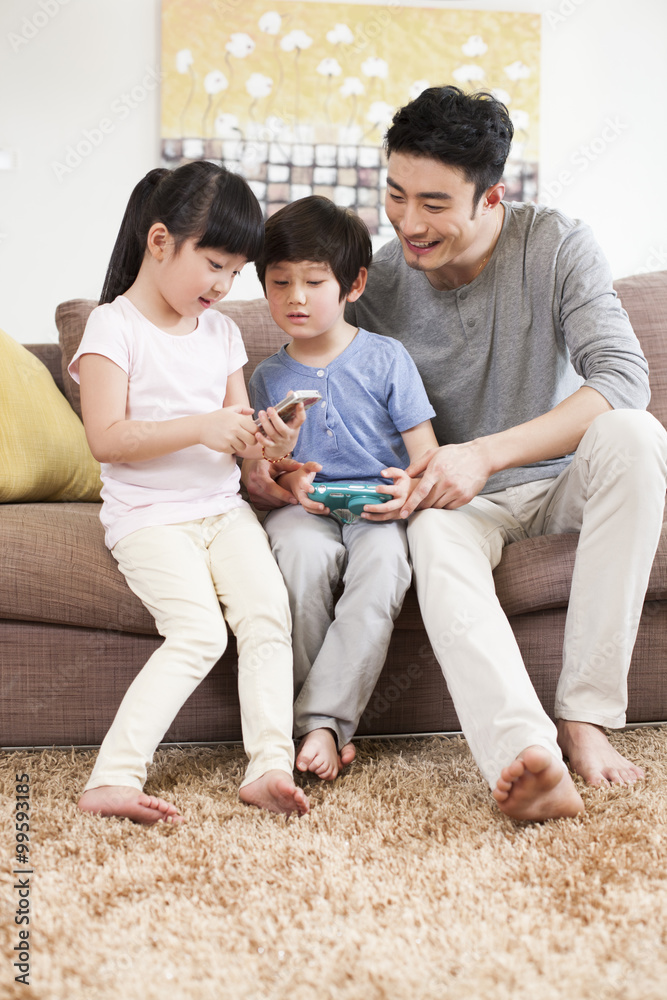 Happy family playing handhold video game in sofa Happy family playing handhold video game in sofa