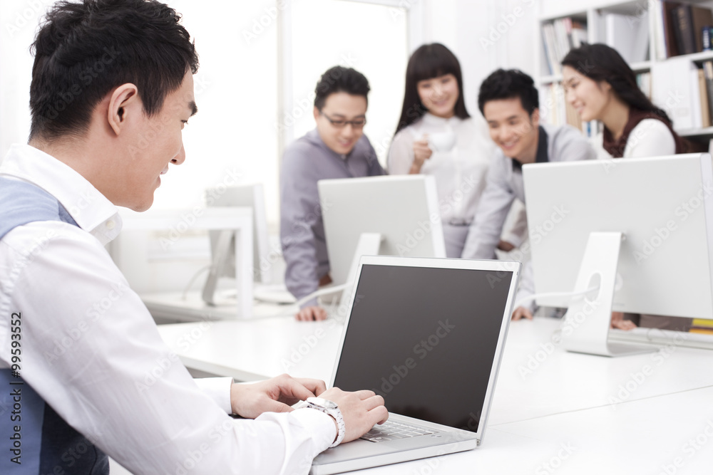 Male office worker using laptop in studio