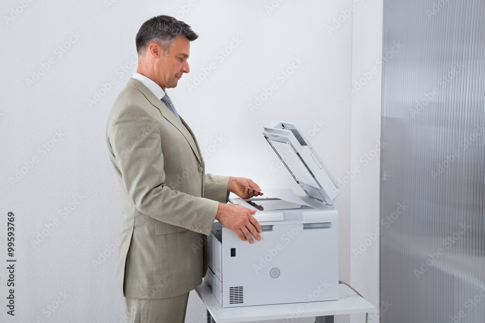 Businessman Keeping Paper On Photocopy Machine In Office