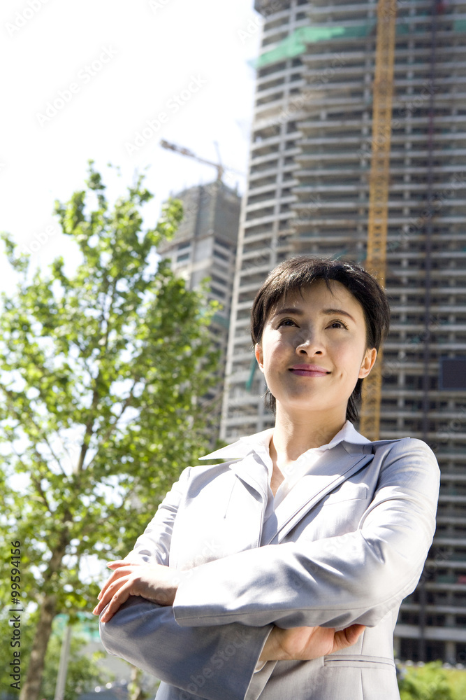 Businesswoman in front of a building under construction Businesswoman in front of a building under construction