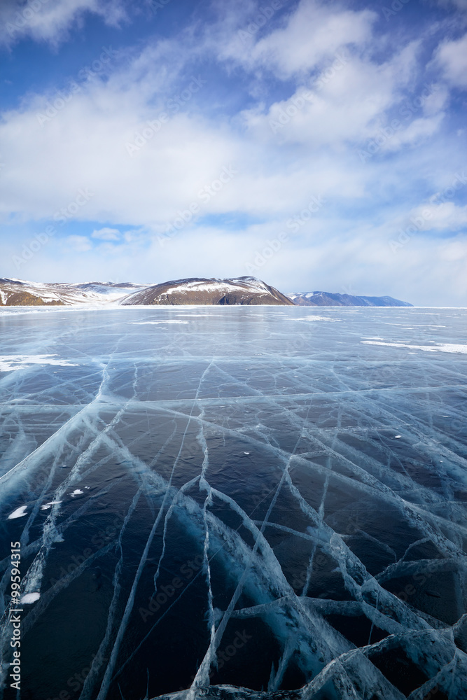 Winter ice landscape on Siberian lake Baikal with clouds