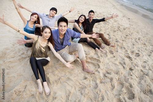 Happy young people sitting on the beach of Repulse Bay, Hong Kong