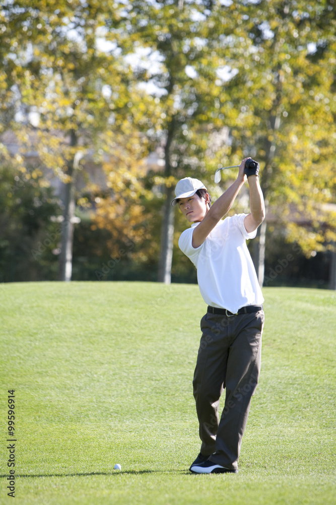 Young Man Taking Practice Golf Swing Young Man Taking Practice Golf Swing