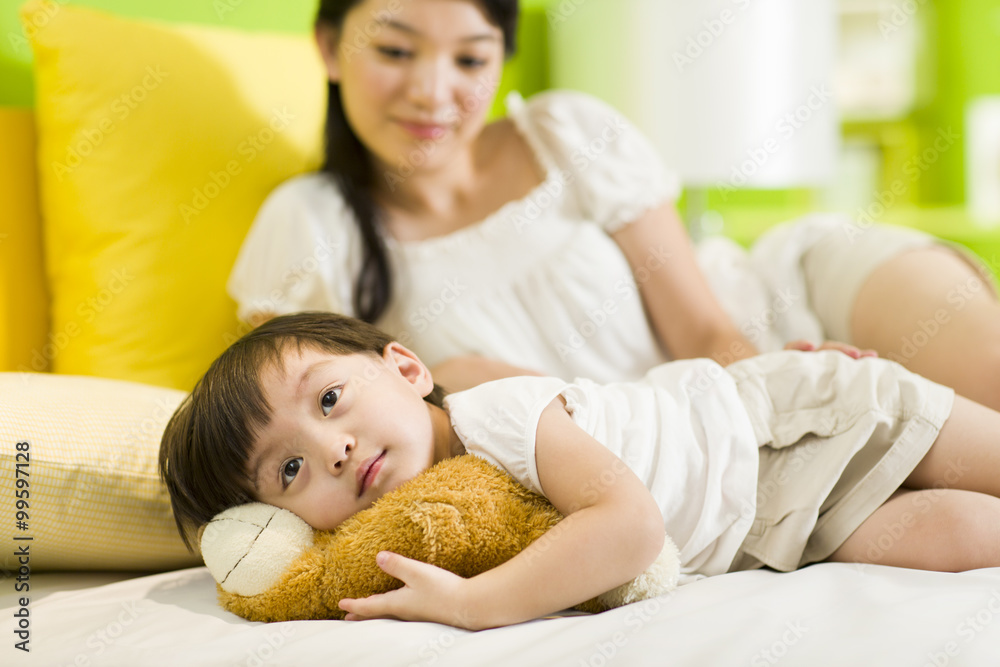 Mother and daughter relaxing in bedroom
