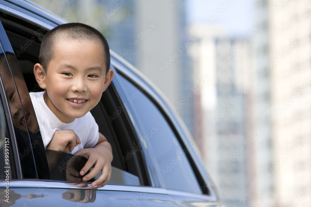 Young boy leaning out car window Young boy leaning out car window
