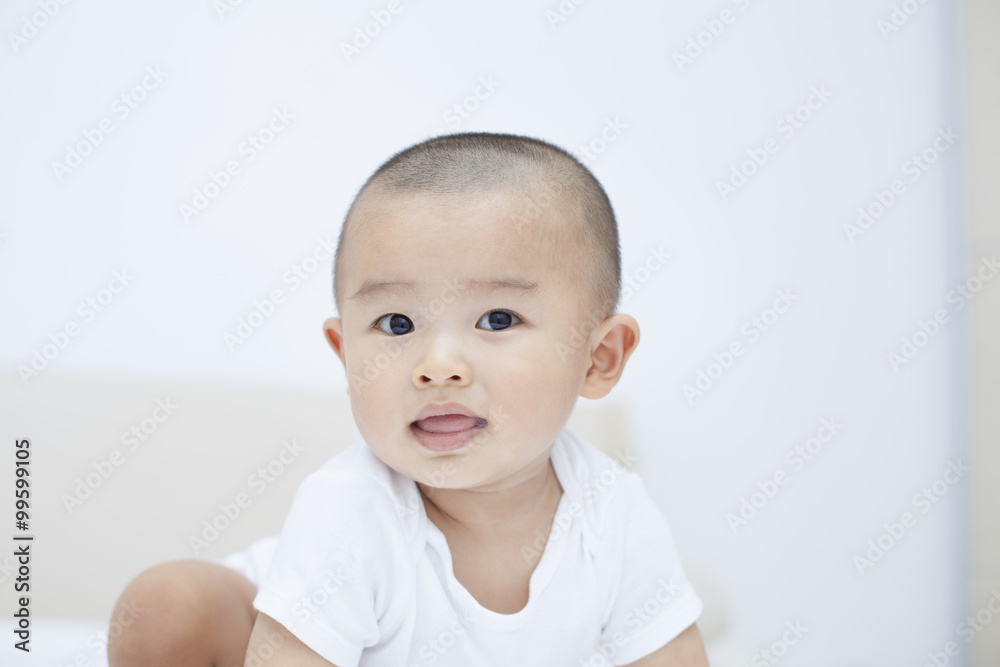 Cute Chinese baby boy crouching in bed