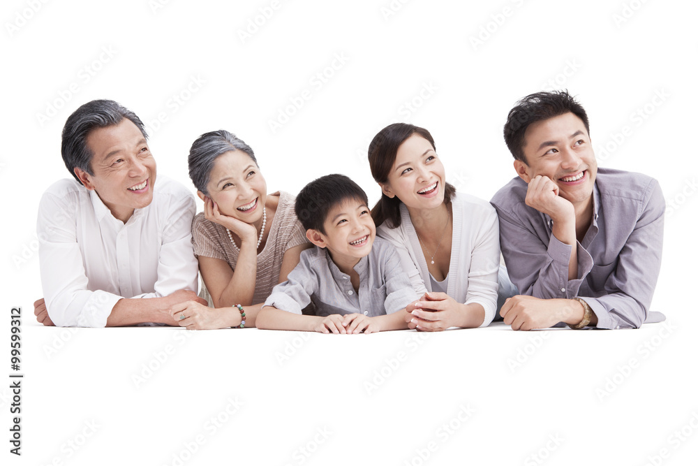 Happy family lying down on ground, looking at view Happy family lying down on ground, looking at view