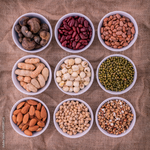 Mixed beans , lentils and nuts in the white bowl on brown cloth