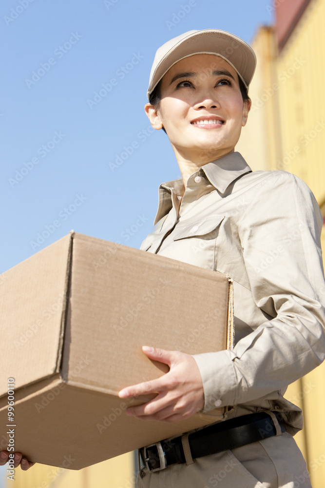 shipping industry worker carrying a cardboard box shipping industry worker carrying a cardboard box