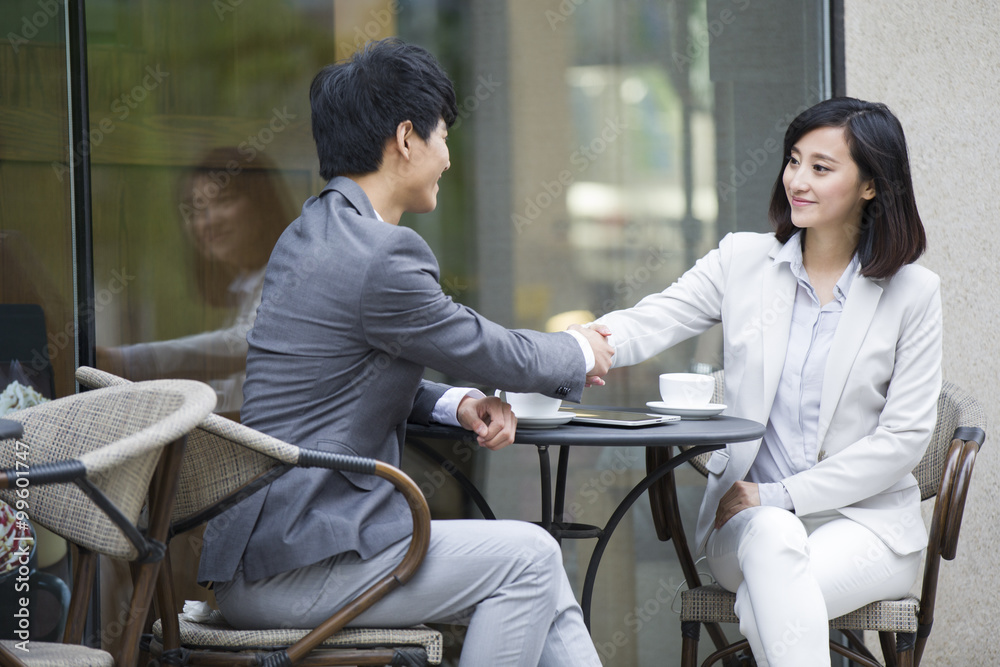 Two business person sitting at outdoor sidewalk café Two business person sitting at outdoor sidewalk café